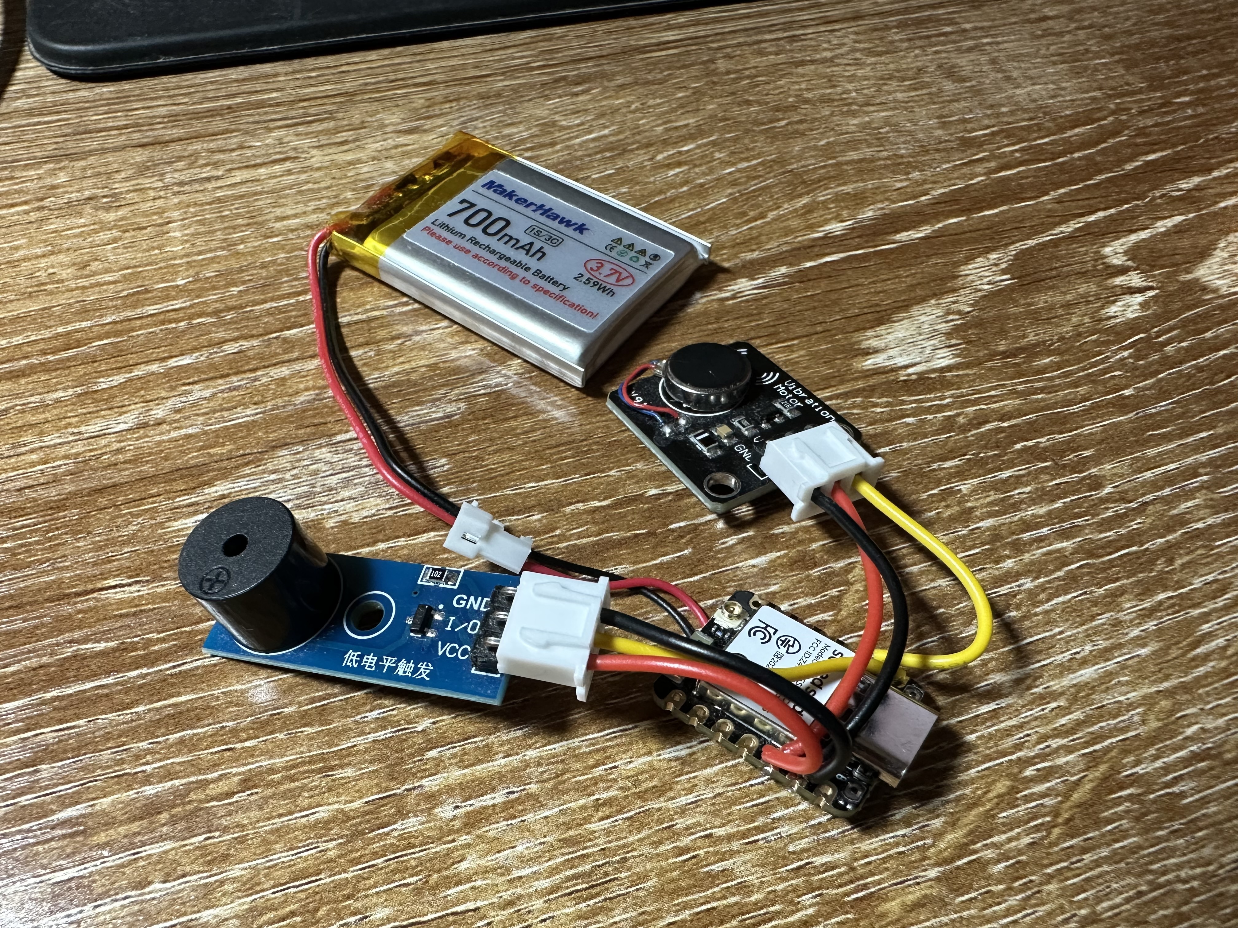 A jumble of wires going between three small circuit boards and a battery.